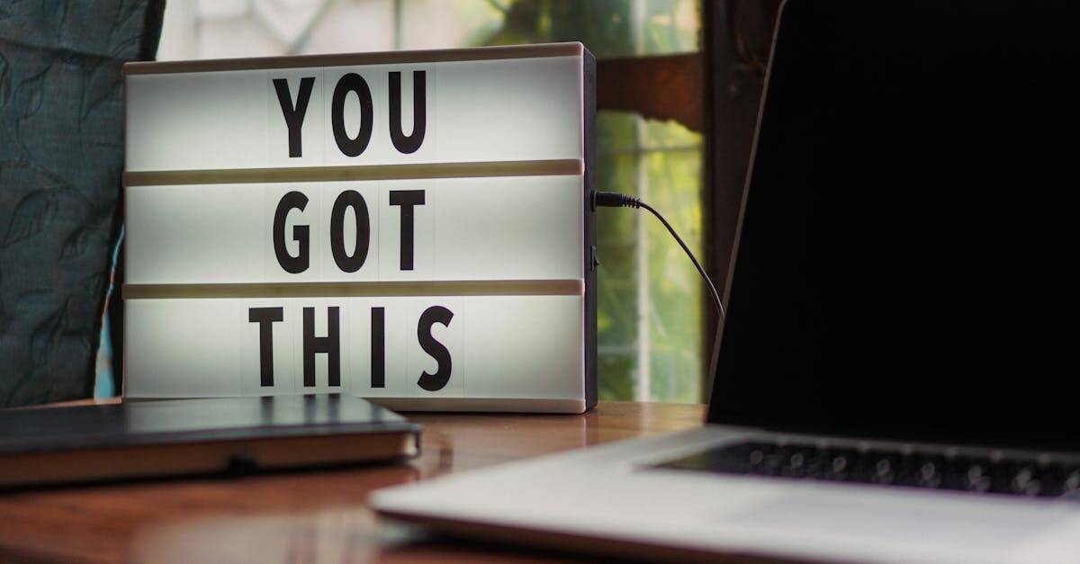 Lit sign with 'You Got This' alongside laptop on office desk.