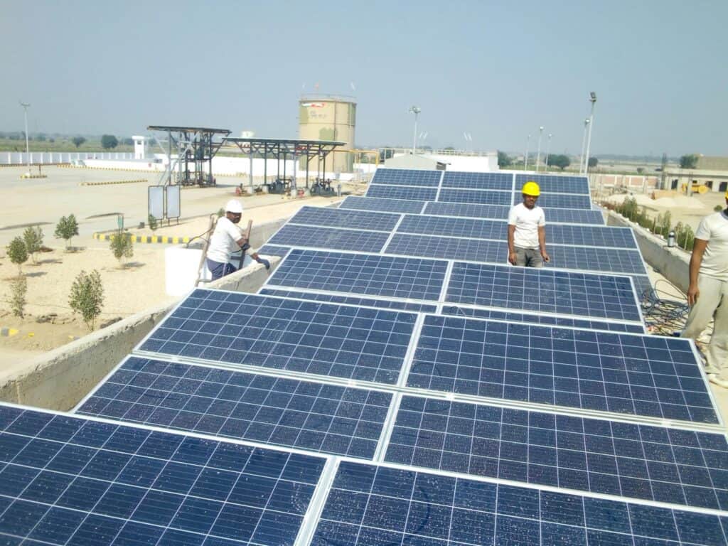Workers installing solar panels on a rooftop for renewable energy generation. Renewable Energy Policies.