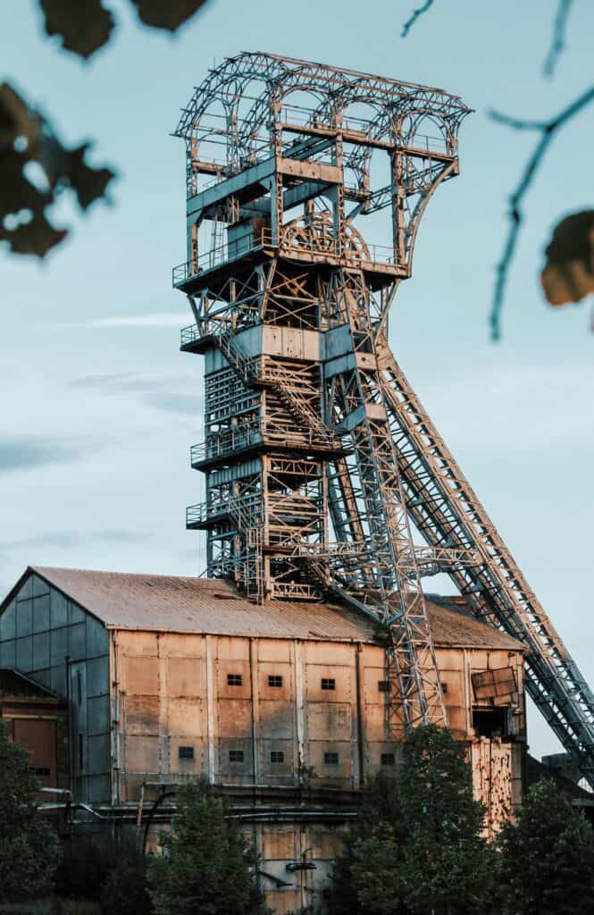 Rusty industrial mining tower in Heusden-Zolder, Belgium during daylight. Electricity market regulations.
